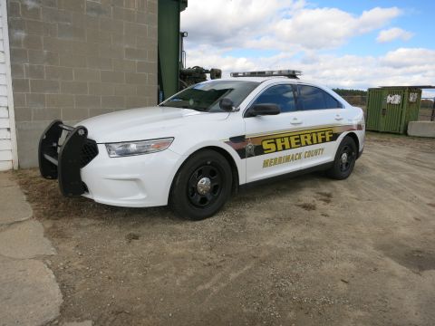 1991 Ford LTD Crown Victoria - Photograph of a Merrimack County Sheriff Ford Taurus patrol car with push bar, not a technical document.