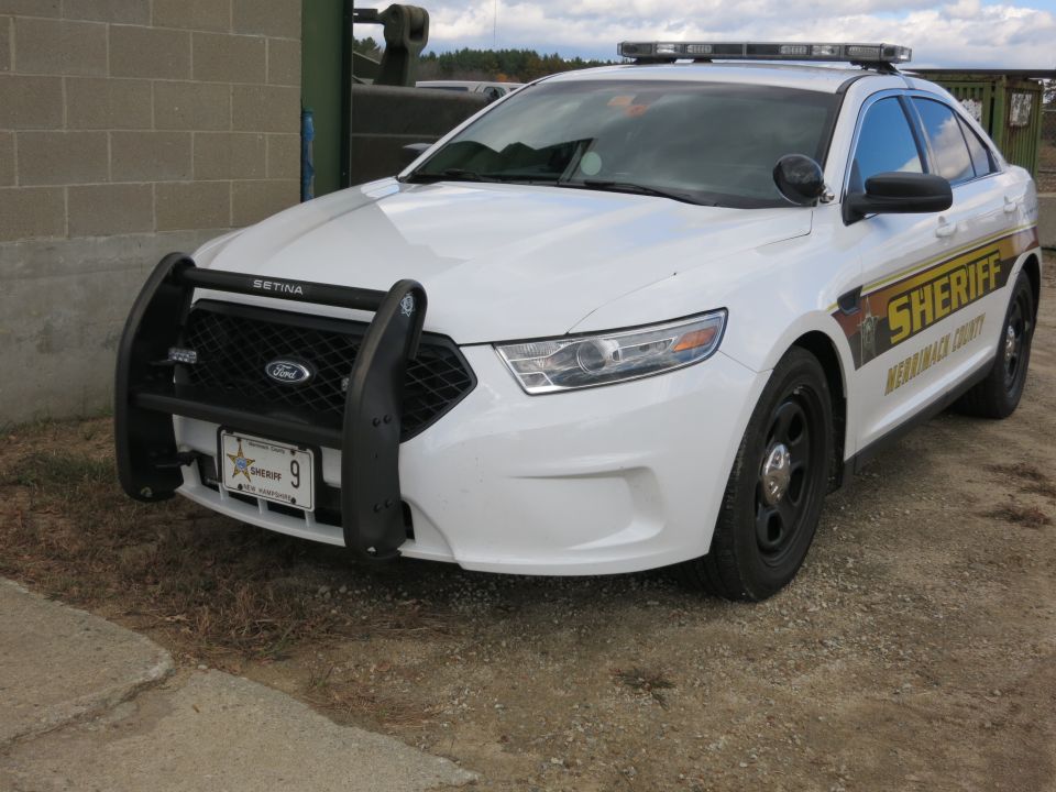White Ford Taurus Sheriff patrol car with push bumper, front view