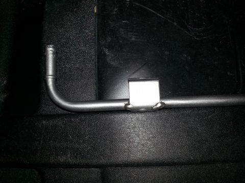 1994 Ford Bronco - Photograph of a bent metal bar or stabilizer rod against a dark plastic surface.