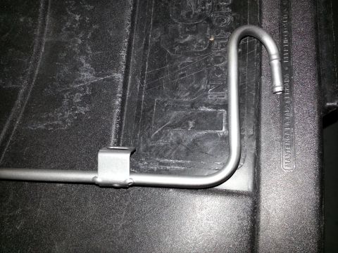 1994 Ford Bronco - Photograph of a bent silver metal tube secured with a clamp on a truck bed liner.
