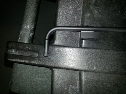 1994 Ford Bronco - Photograph of a black bent metal rod laid across dark plastic panels.