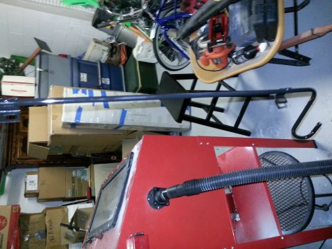 1994 Ford Bronco - Photograph of a cluttered garage interior with stored boxes, tools, and a long metal bar across the frame.