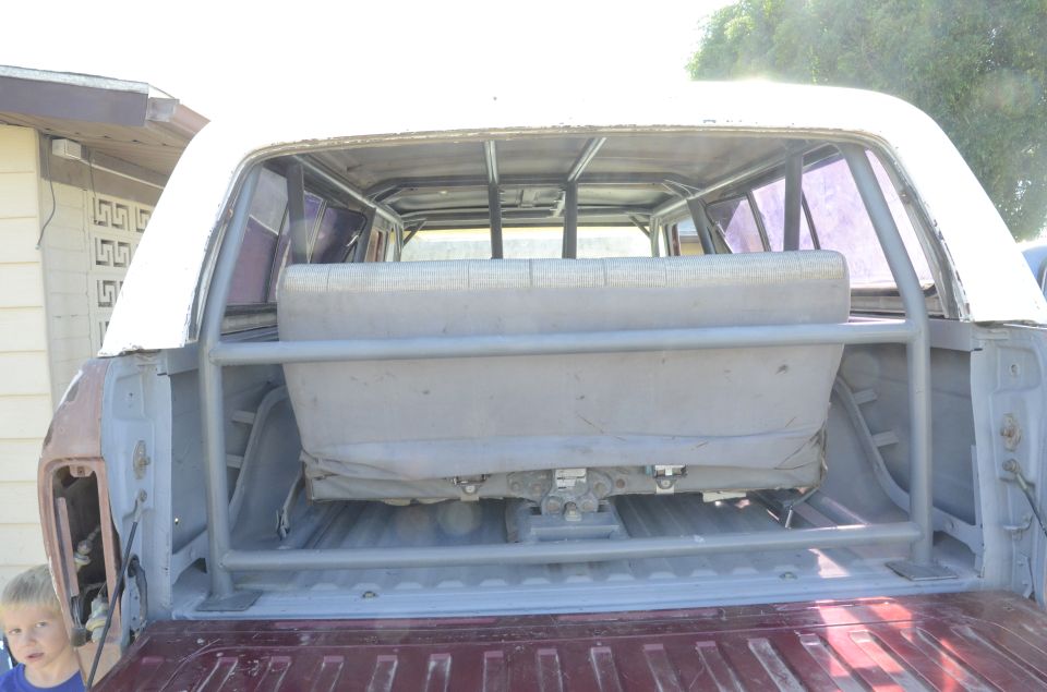 Rear interior of a pickup truck with roll cage and bench seat.