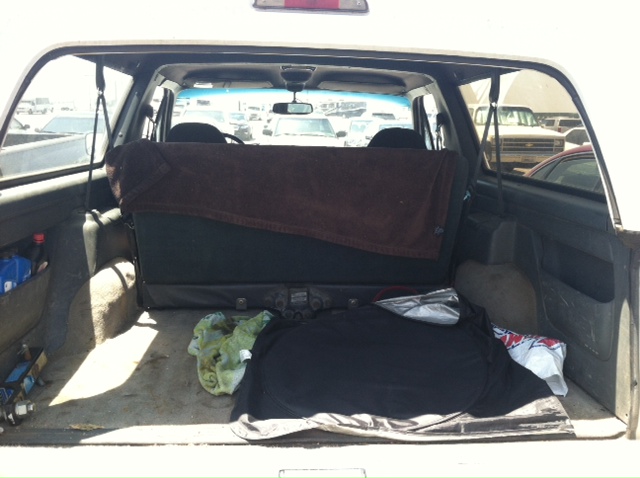 Open rear cargo area of a white SUV with items inside.