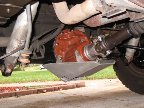 1994 Ford Bronco - The underside of a 1994 Ford Bronco shows a differential housing painted orange, with a silver skid plate mounted underneath. A driveshaft…