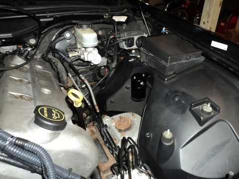 2004 Mercury Grand Marquis - The engine bay of a 2004 Mercury Grand Marquis shows a black oil catch can mounted to the inner fender well, next to the brake fluid reserv…