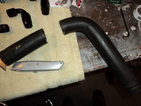 2004 Mercury Grand Marquis - A close-up view of black rubber hoses and a utility knife on a textured surface.