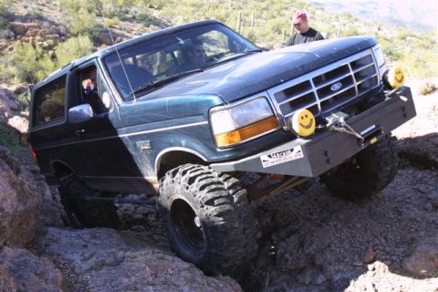 1994 Ford Bronco - This modified 1994 Ford Bronco is shown off-roading on a rocky trail with a person observing.