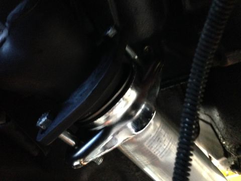1992 Ford F-150 - Close-up view of a vehicle's exhaust pipe connection, showing shiny metal and black tubing.