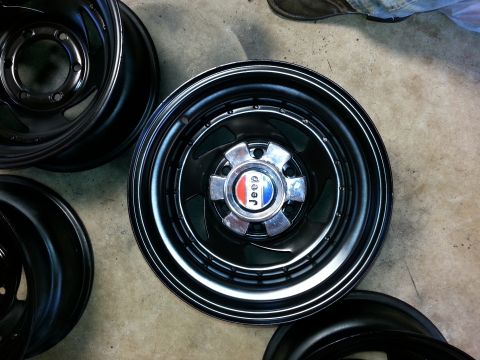 1982 Jeep Wagoneer - A close-up of a Jeep wheel and hubcap, with other wheels visible in the background.