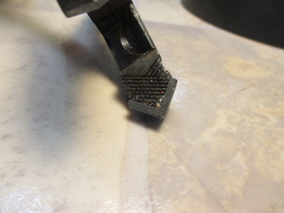 Close-up of a textured metal part with a diamond plate pattern