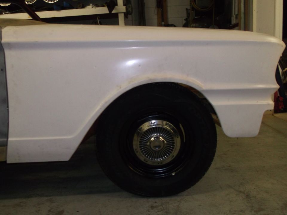 White 1964 Ford Fairlane front fender and wheel, side view, in garage