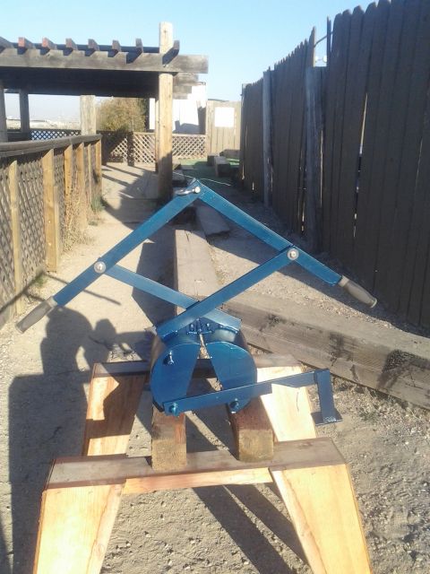 1991 Ford Bronco - A blue mechanical device, possibly a tool or part, is shown resting on wooden supports outdoors.