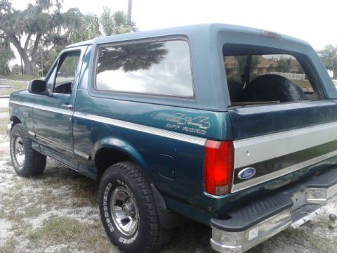 1996 Ford Bronco - The rear quarter panel of a green Ford Bronco shows a 4x4 Off Road decal and a Ford emblem.