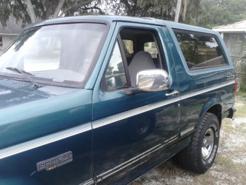 1996 Ford Bronco - This 1996 Ford Bronco XLT is seen from a 3/4 front angle, highlighting its teal paint and chrome trim.