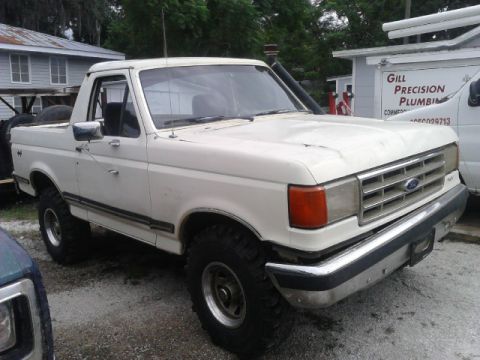 1988 Ford Bronco - This white Ford Bronco features off-road tires and a snorkel. The body style indicates it is likely from the late 1980s or early 1990s.