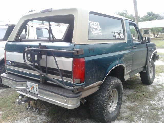 1996 Ford Bronco rear view, two-tone paint, spare tire carrier, license plate BZO M14. Another vehicle is partially visible to the left