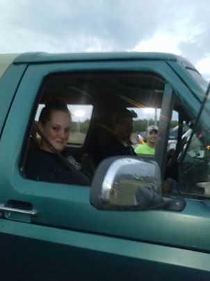 1996 Ford Bronco - A woman smiles from the driver's seat of a green 1996 Ford Bronco, with two men visible in the background.
