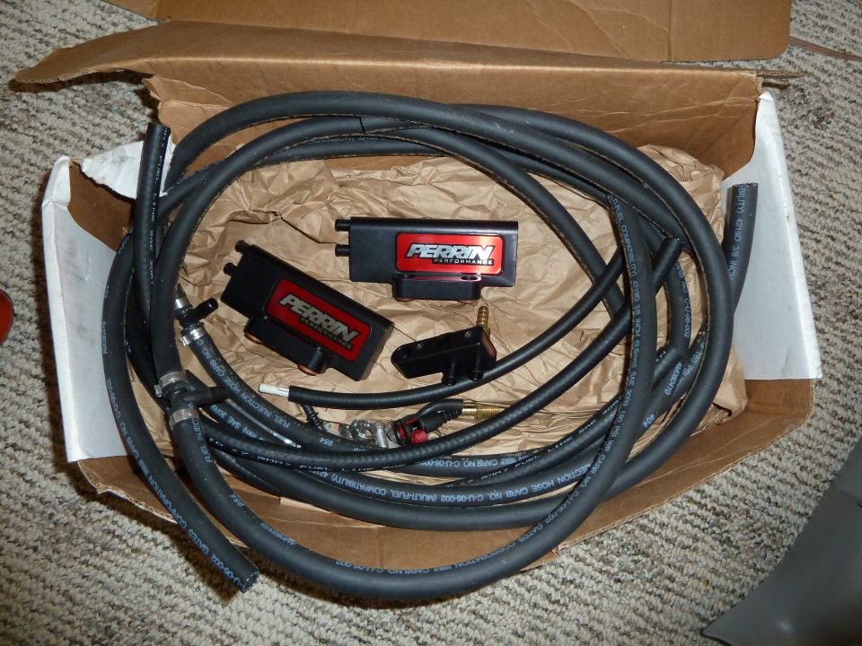 Perrin Performance fuel line kit with two black boxes and hoses in a cardboard box