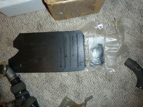 2007 Subaru Impreza - A collection of car parts, including mud flaps and hoses, are laid out on a carpeted floor.