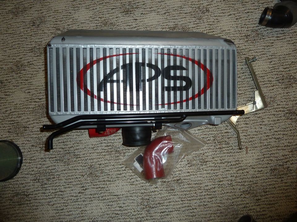 APS intercooler with red oval logo, black piping, and red silicone coupler