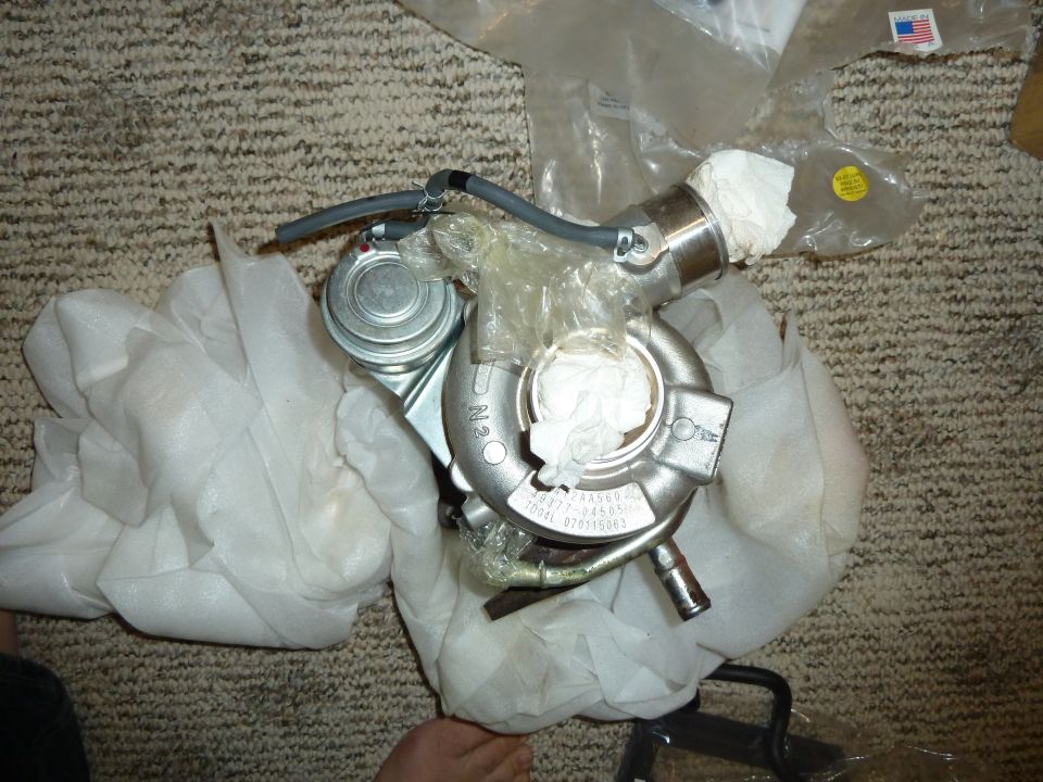 Turbocharger with part numbers visible, wrapped in protective material
