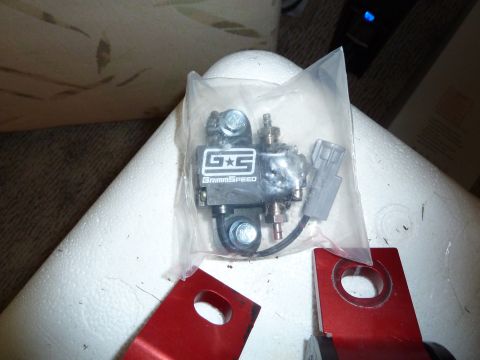 2007 Subaru Impreza - A GrimmSpeed part is shown in plastic packaging alongside red metal brackets.