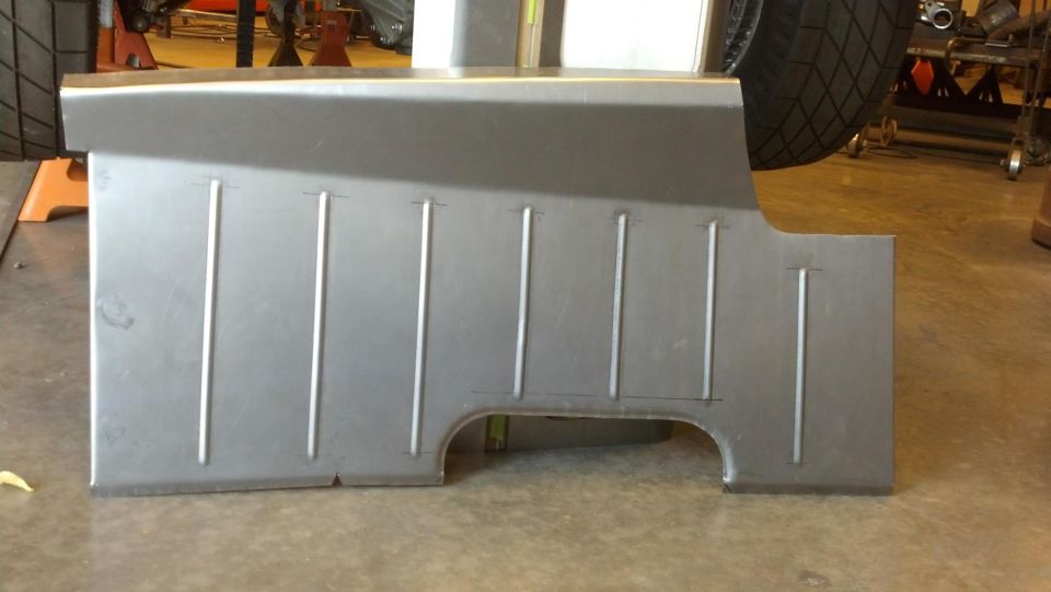 Sheet metal floor pan section with vertical ribs and cutouts